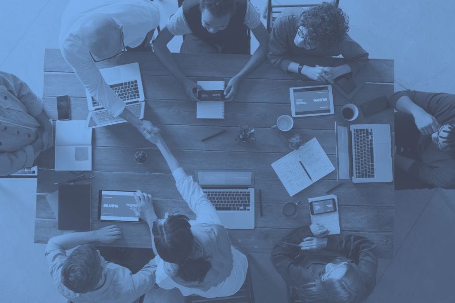 Full service engagement image with people collaborating around a table